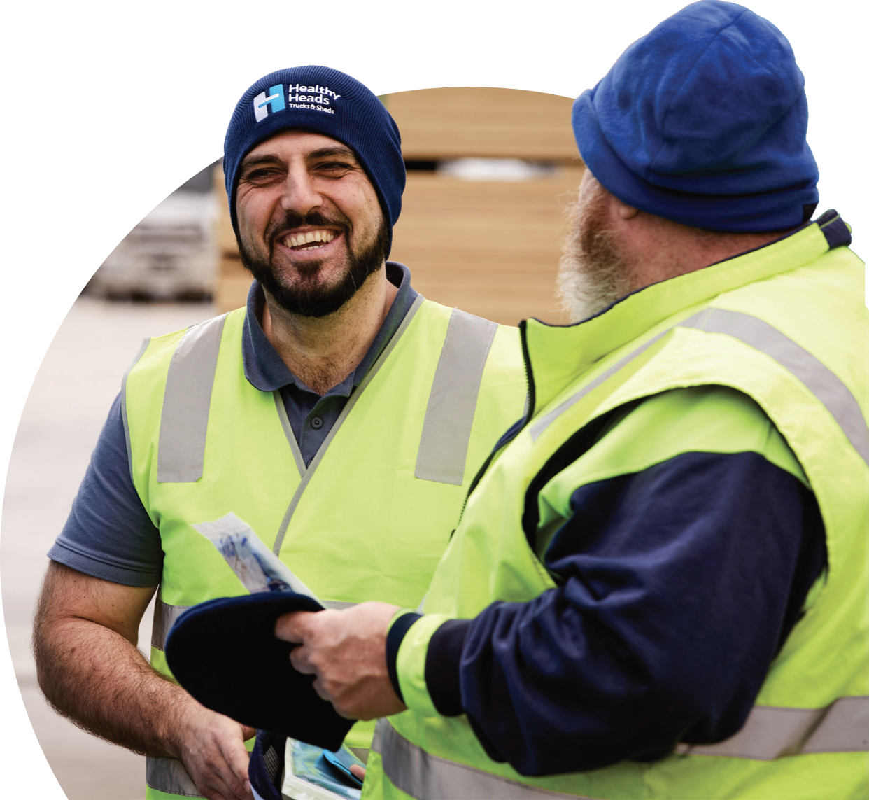 Two heavy vehicle industry workers talking on site